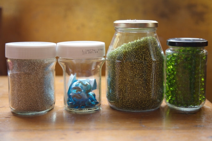 Glass jars are reused to store beads, mosaic tiles and spices